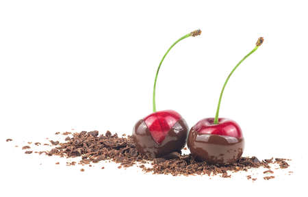 Two red cherries in chocolate dipped with grated chocolate isolated on a white backgroundの写真素材