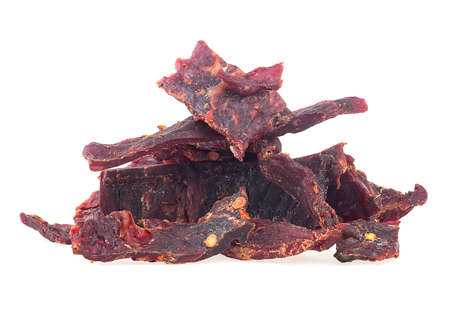 Portion of spiced beef jerky isolated on a white white background. Dried peppered beef jerky.の写真素材