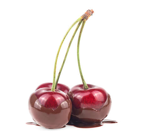 Three ripe cherries in hot milk chocolate isolated on a white backgroundの写真素材