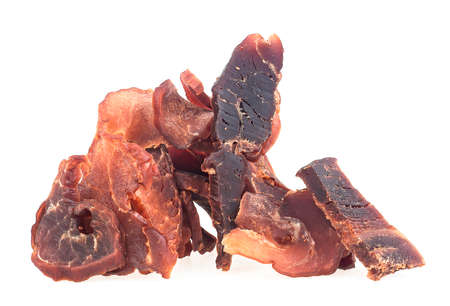 Portion of sliced and dried meat isolated on a white background. Pile of pork jerky pieces.の写真素材