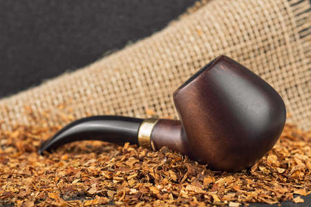 Classic wooden pipe with tobacco on linen canvas backgroundの写真素材