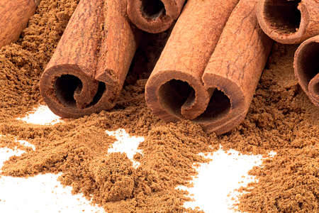 Cinnamon sticks with cinnamon powder on a white background, close up.の写真素材