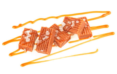Salted caramel candies with caramel sauce isolated on a white background. Toffee candies.の写真素材