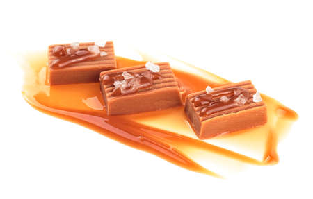 Salted caramel candies with caramel sauce isolated on a white background. Toffee candies.の写真素材