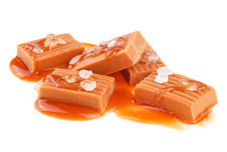 Salted toffee candies with caramel sauce isolated on a white background. Golden Butterscotch toffee caramels.の写真素材
