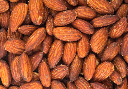Pile of salted and roasted almond nuts as background. Tasty smoked nuts.の写真素材