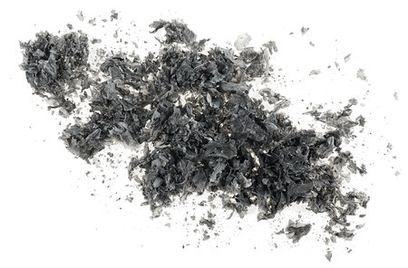 Top view of burned and charred paper scraps isolated on a white backgroundの写真素材