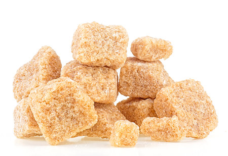 Brown cane sugar pieces isolated on a white background. Unrefined demerara.の写真素材