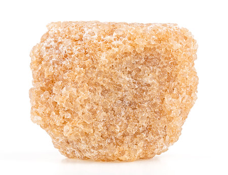Brown cube of cane sugar isolated on a white background, close up.の写真素材