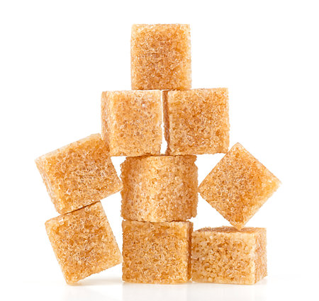 Pile of brown cane sugar cubes isolated on a white background. Pyramid.の写真素材