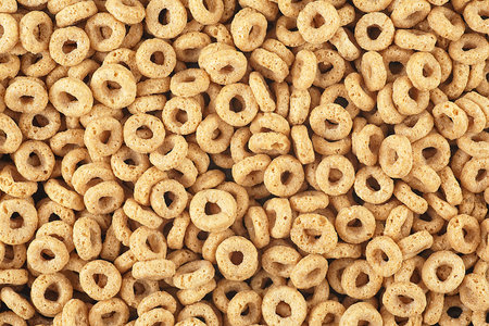 Delicious cereal rings with honey as background, top view. Breakfast cereal.の写真素材