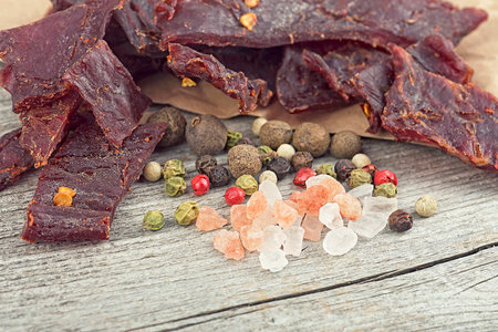 Portion of spiced beef Jerky on vintage wooden backgroundの写真素材