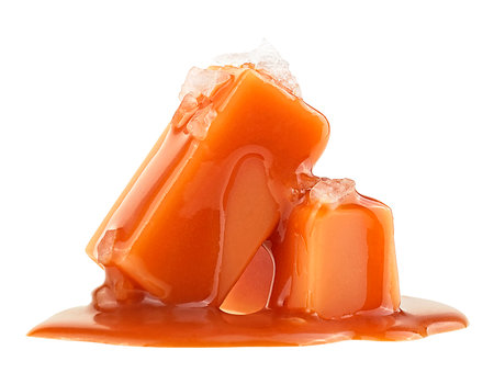 Delicious candies with flowing caramel sauce and sea salt isolated on a white backgroundの写真素材