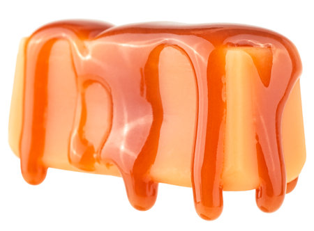 Caramel sauce flowing on caramel candy, isolated on a white background. Caramel candy with liquid caramel.の写真素材