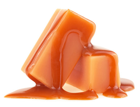 Two caramel candies and milk caramel sauce isolated on a white backgroundの写真素材