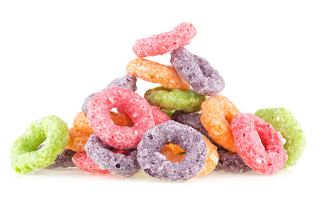 Pile of sweet crispy corn rings isolated on a white background. Cereal breakfast. Fruit loops. Colorful corn cereals.の写真素材