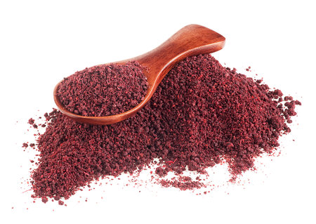 Ground sumac spice pile in wooden spoon isolated on a white backgroundの写真素材