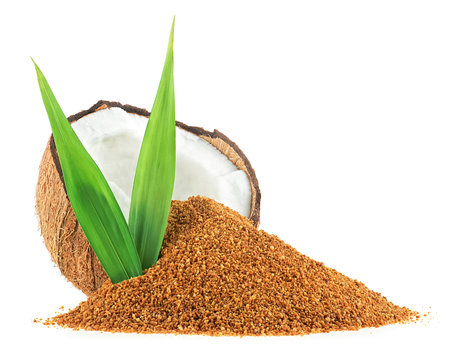 Half of coconut, green palm leaves and brown coconut sugar isolated on a white background. Healthy sugar alternative.の写真素材