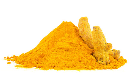 Pile of curcuma powder and dried turmeric roots isolated on a white backgroundの写真素材