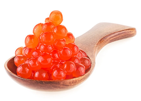 Salmon red caviar in brown wooden spoon isolated on a white background. Raw seafood, delicious red caviar.の写真素材