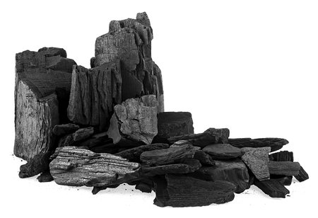 Pile of black charcoal chunks isolated on a white background. Natural wood charcoal.の写真素材