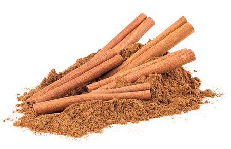 Pile of ground cinnamon and cinnamon sticks isolated on a white background. Spices.の写真素材