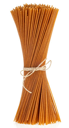 Bundle of uncooked whole grain spaghetti tied with rope, isolated on a white background.の写真素材