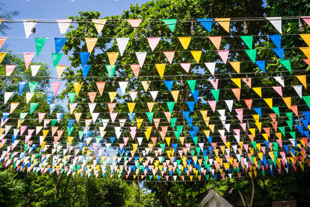 Multi colored triangular Flags Hanging in the sky on outdoor road at celebration partyの写真素材