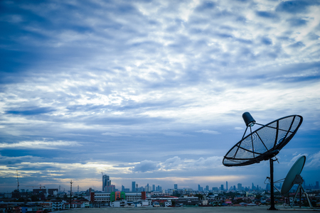 Satellite dish antenna on top of the building in urban area at morningの写真素材