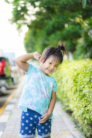 portrait of happy little girl standing ing in the parkの写真素材