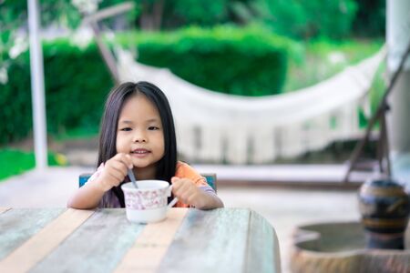 little asian girl prepare hot cocoa or chocolate to drinking for enjoy breakfast in morningの写真素材