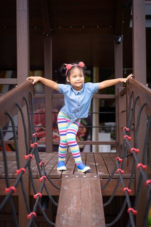 portrait of asian little girl on the bridge in the playgroundの写真素材