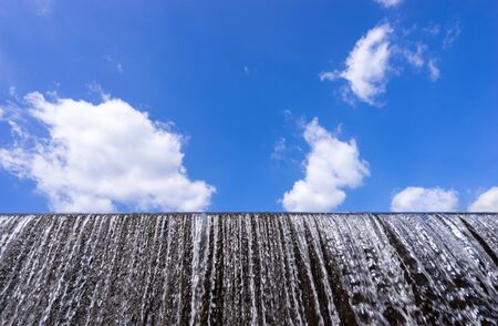 water flow at weir and blue skyの写真素材