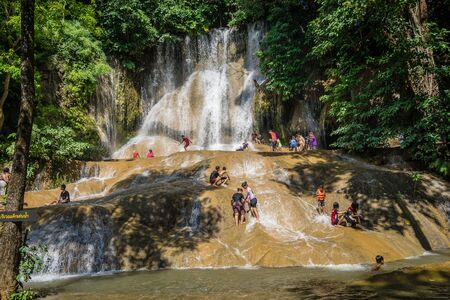Kanchanaburi, Thailandâ -â  October 7, 2018â: Tourists playing Sai Yok Noi Waterfall to cool off in holidayのeditorial素材