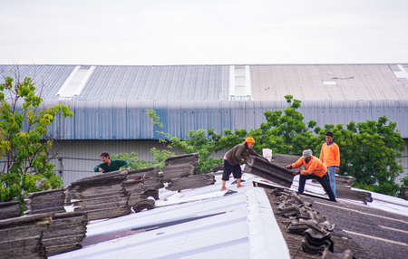Samutprakan,Thailand - July 6, 2019 : Workers are repairing the roof on a cloudy dayのeditorial素材