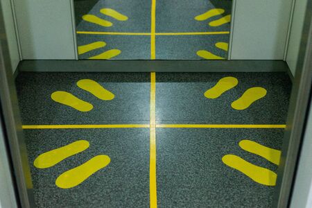 Signs caution social distancing in elevator in condominium for protect pandemic of virus Covid-19の写真素材