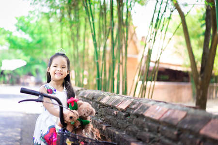 little asian girl wearing cap with grass flower in the parkの写真素材