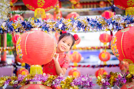 cute little asian girl in chinese traditional dress smiling in the temple.Happy chinese new year concept.の写真素材