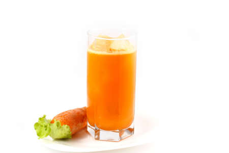 Freshly squeezed carrot juice is poured into a glass with iceの写真素材