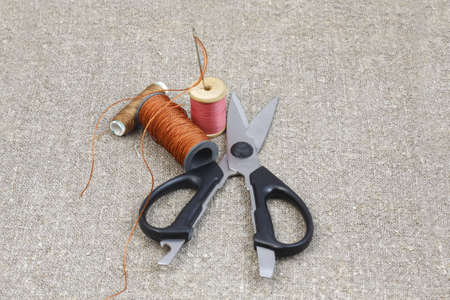 scissors, thread and needle to coarse gray canvas of matsの写真素材