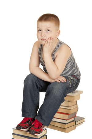 boy sitting on the books of his head in his hands isolated on white background
の写真素材