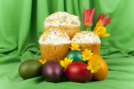 Easter cake and colored eggs on a background of green material