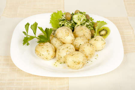 Early potatoes cooked with salad on the plateの写真素材