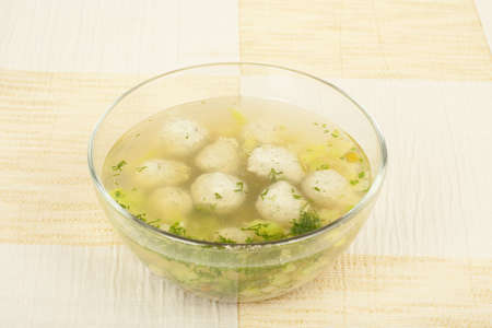 Chicken soup with vegetables and quenelles in a glass bowlの写真素材