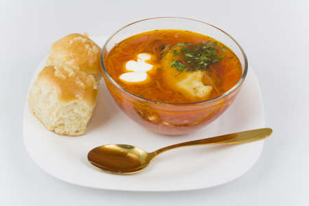 Ukrainian borsch with donuts in a glass bowl