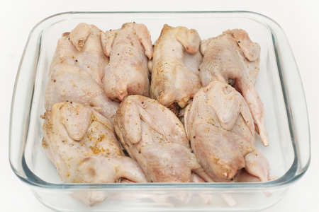 marinated raw quail carcass closeup in a glassの写真素材