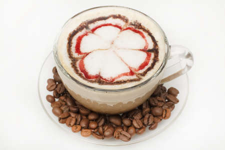 cappuccino in a glass cup with coffee beans on the saucer