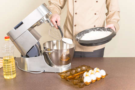 cook prepares dough for pancakes on a food processor
