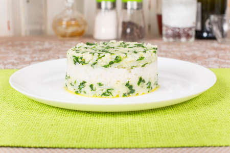 boiled rice with spinach molded using a pastry ringの写真素材