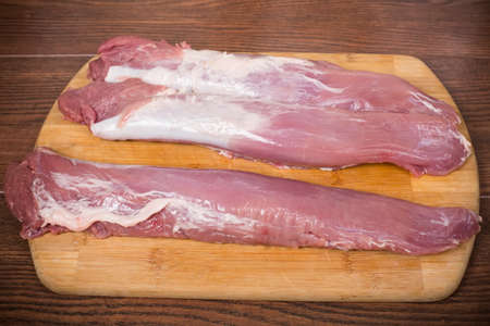 raw pork tenderloin on a cutting Boardの写真素材